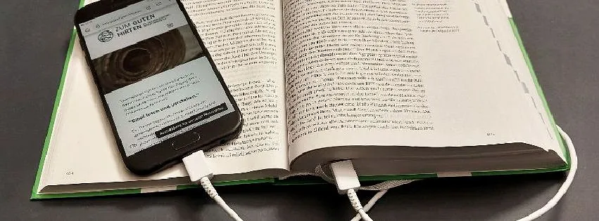 Offen Bibel mit einem Smartphone verbunden