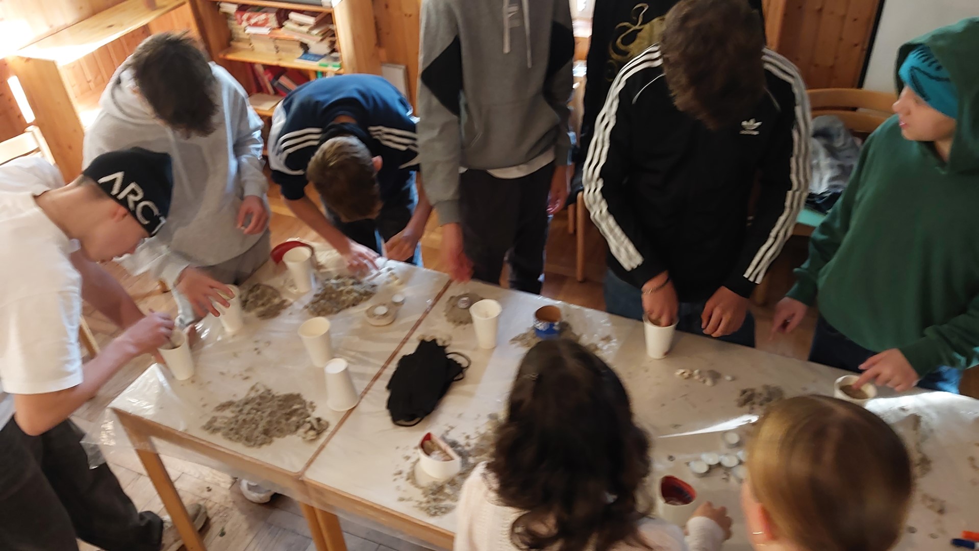 Vier Jugendliche beugen sich über einen Altar und machen Notizen